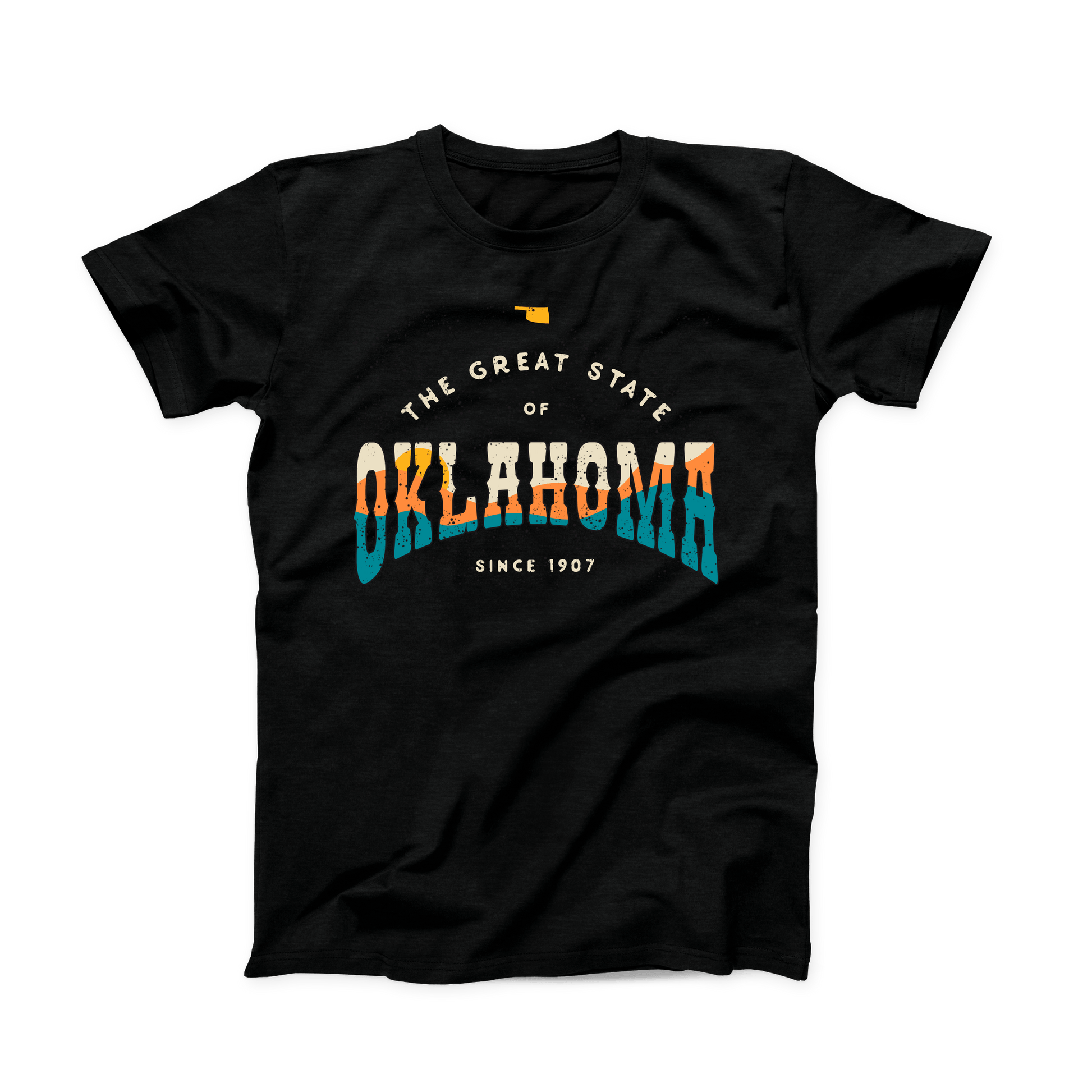 Black Oklahoma t-shirt. Small Oklahoma state shape at the top in yellow gold. "The Great State of Oklahoma since 1907" listed under the state. "Oklahoma" is the largest font on the shirt with a sunset over hills shown within the word in cream, yellow, orange, and teal.
