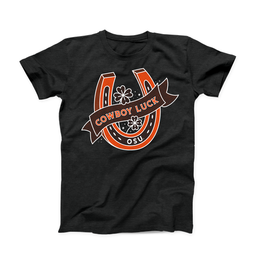 Black heather OSU shirt for March. Orange and white design of an upright horseshoe with 4 leaf clovers inside and "OSU" on the bottom. A banner with "Cowboy Luck" across the front.