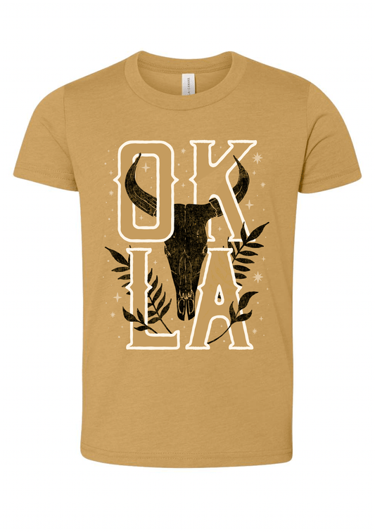 Front of youth heather mustard t-shirt with longhorn skull and bold OKLA lettering. August 2021 Oklahoma Shirt of the Month.