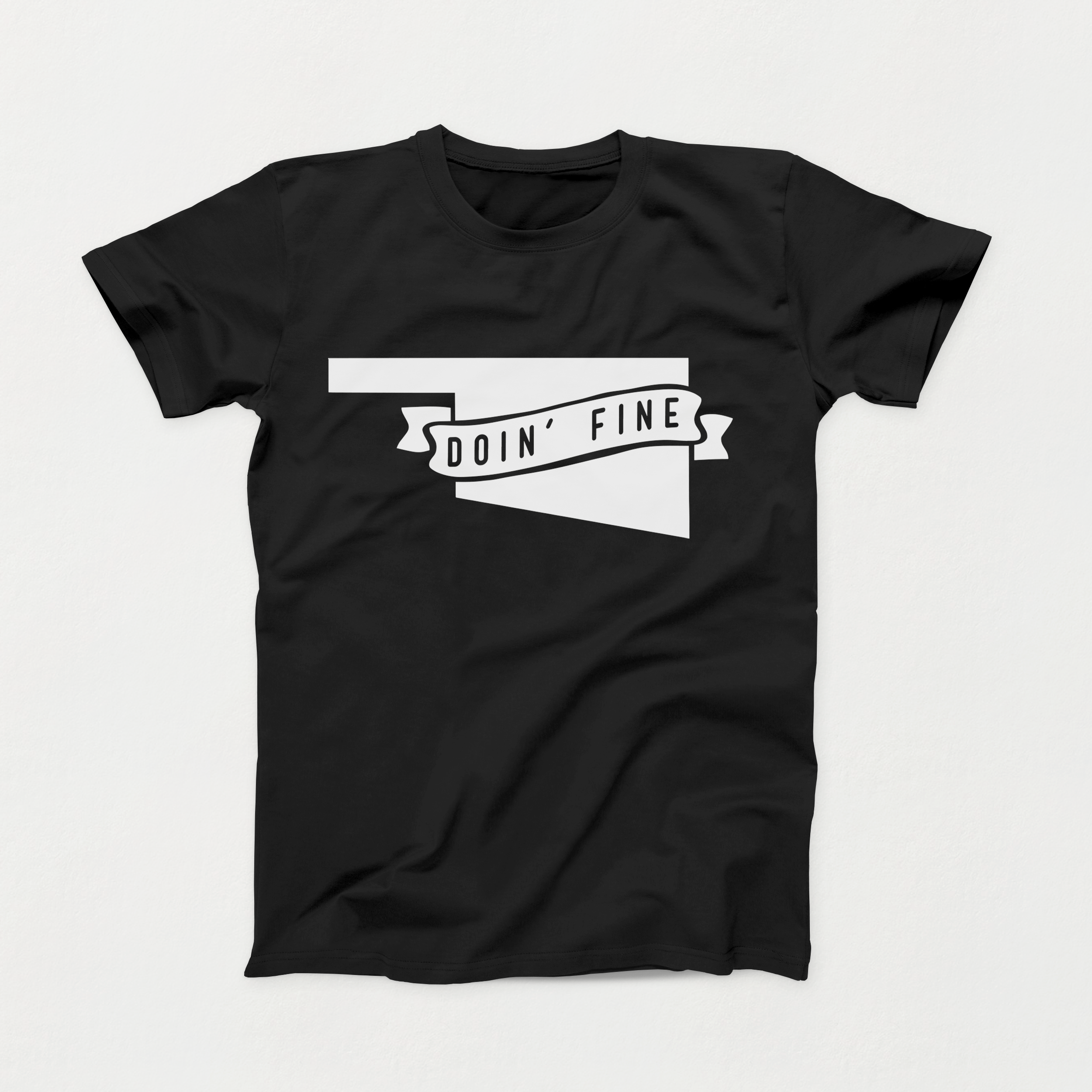 Black t-shirt with white Oklahoma outline and ribbon reading “Doin’ Fine,” Intro Shirt of the Month