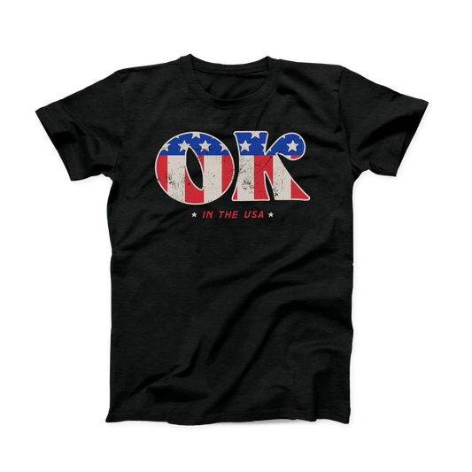 Solid black colored Oklahoma t-shirt. Screen printed in a vintage, distressed style is a large "OK" with the American flag print inside the letters.  And in smaller font below is "IN THE USA" in red with a small white star on either side. 