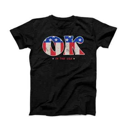 Solid black colored Oklahoma t-shirt. Screen printed in a vintage, distressed style is a large "OK" with the American flag print inside the letters.  And in smaller font below is "IN THE USA" in red with a small white star on either side. 