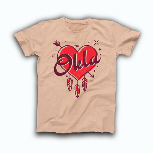 Heather Peach colored Oklahoma T-shirt. Design is a red Heart, outlined in maroon, with an arrow through it and 3 feathers hanging from the bottom. Scrawled across the heart in a maroon font is "Okla."